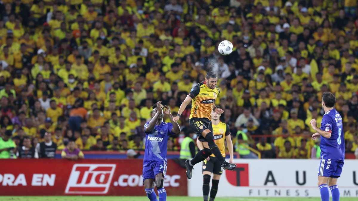El volante de Barcelona Bruno Piñatares (d), cabecea una pelota junto al delantero de Emelec Alejandro Cabeza (i) en el Clásico del Astillero de mayo de 2022.
