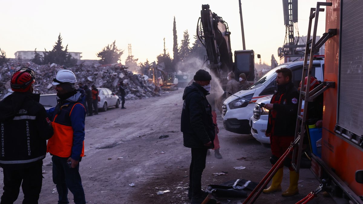Trabajadores de búsqueda y rescate se desinfectan entre sí tras sus turnos cerca de edificios derrumbados en Hatay Turquía.