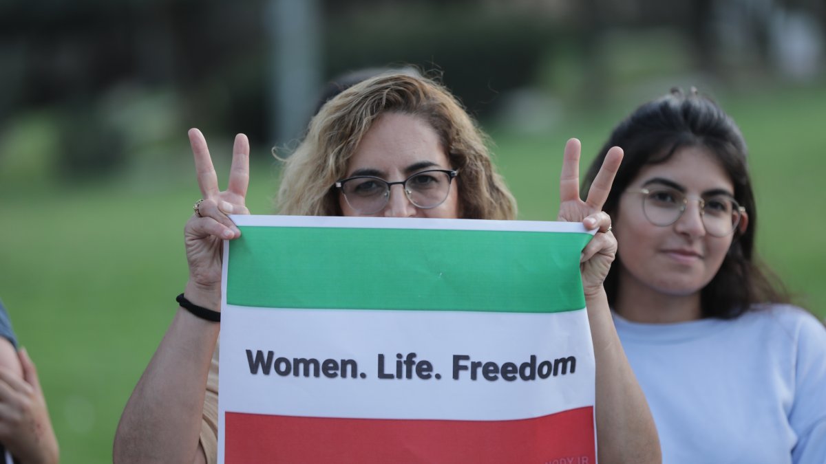 Imagen de archivo de una protesta donde una mujer enseña una bandera iraní con el eslogan: 