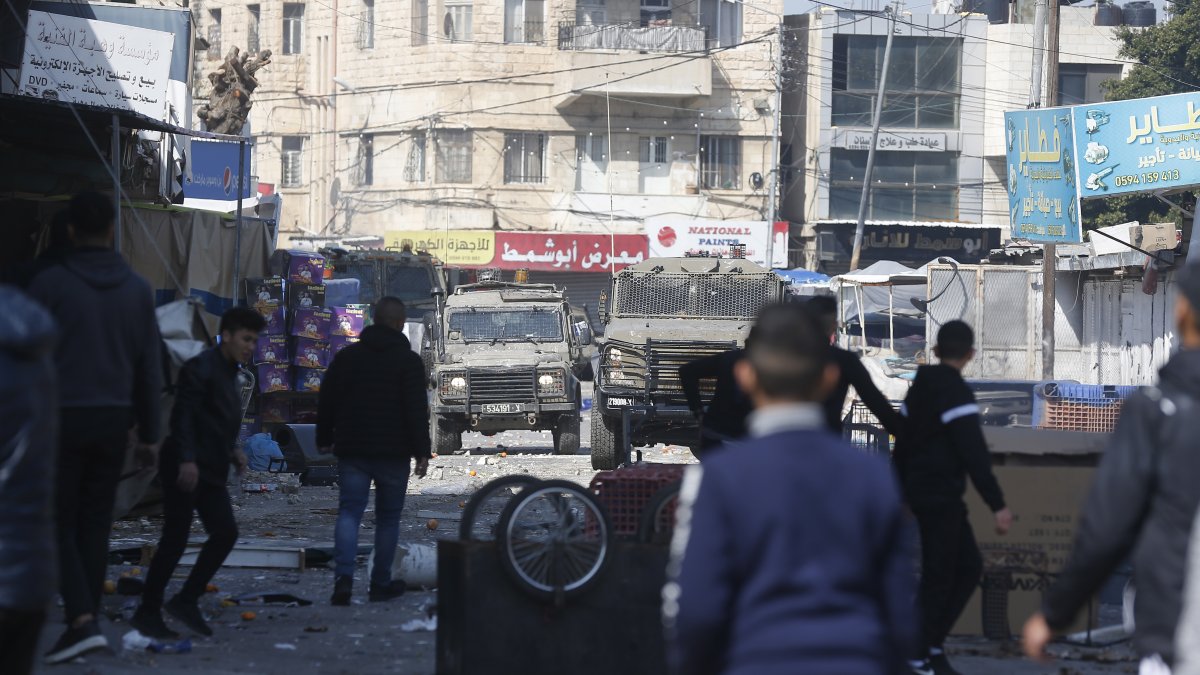 Palestinos arrojan piedras durante una operación israelí en la ciudad de Naplusa, en Cisjordania, el miércoles 22 de febrero de 2023.