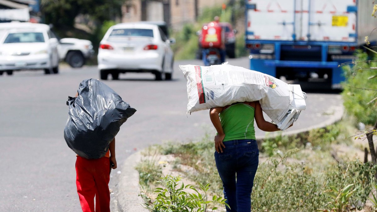Dos niños cargan bolsas donde llevan botes plásticos para reciclar en Olancho (Honduras), en una fotografía de archivo.