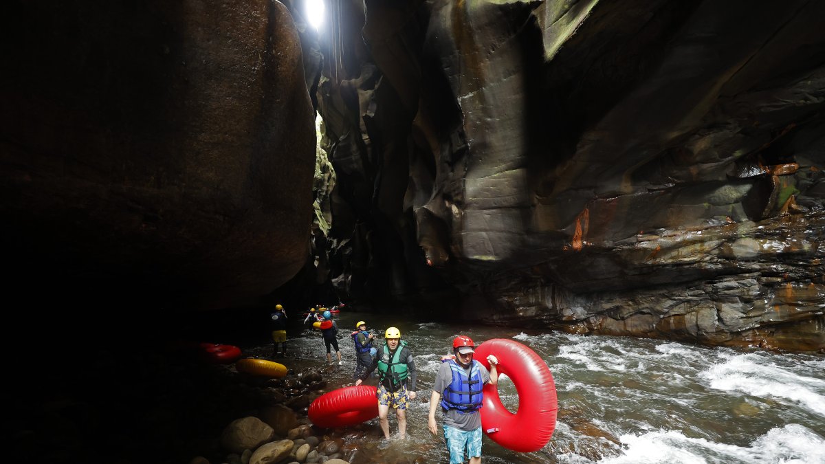 La Uribe. Turistas caminan por el cañón del río Guape, el 18 de febrero de 2023, en departamento del Meta (Colombia).  Buscan un poco de diversión en la selva montañosa.