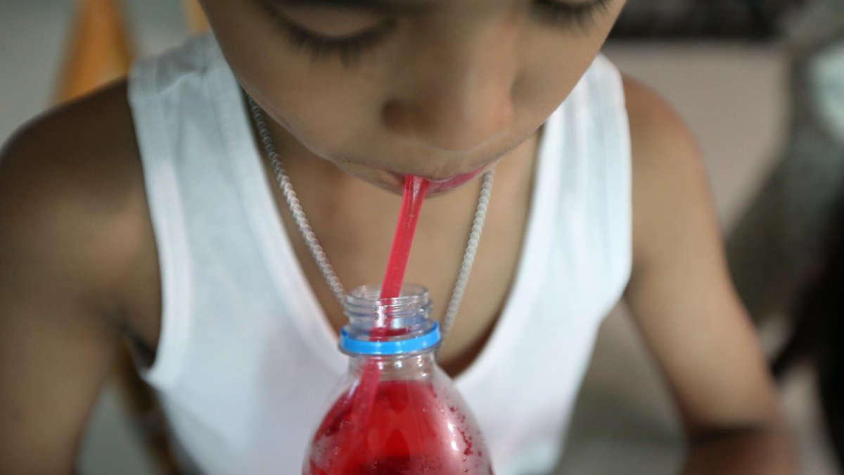 En la imagen de archivo, un niño se bebe un refresco en Bangkok (Tailandia).