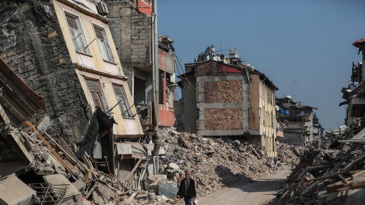 Un hombre pasa junto a edificios derrumbados tras los fuertes terremotos en Hatay, Turquía, el 23 de febrero de 2023.