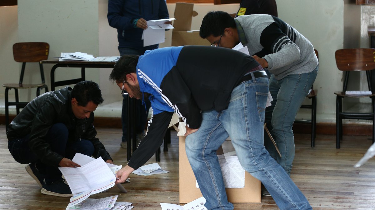 Vocales de una mesa de votación realizando el proceso de conteo de votos, tras el cierre del sufragio.