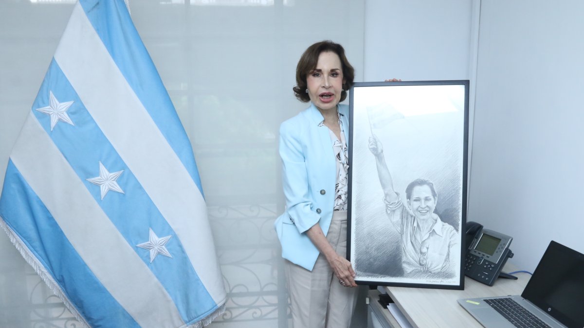 La exfuncionaria posa con un retrato en su oficina