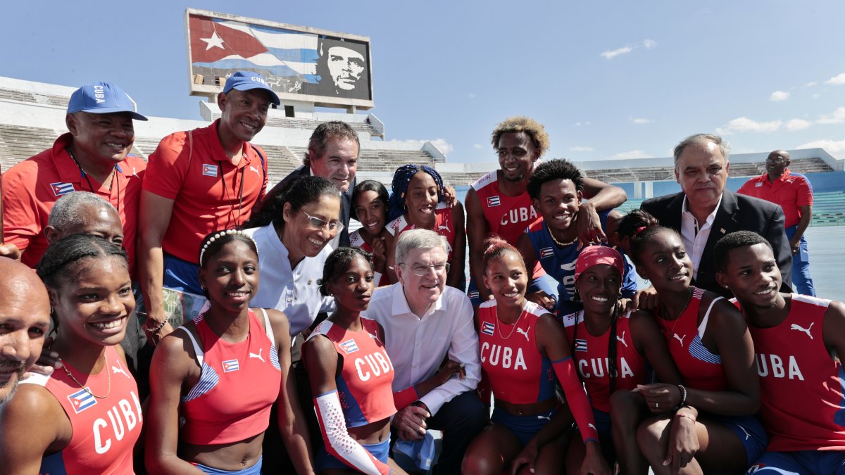 El presidente del Comité Olímpico Internacional (COI), el alemán Thomas Bach (c), posa con atletas cubanos durante un recorrido para la inauguración de una pista de atletismo, en La Habana (Cuba).