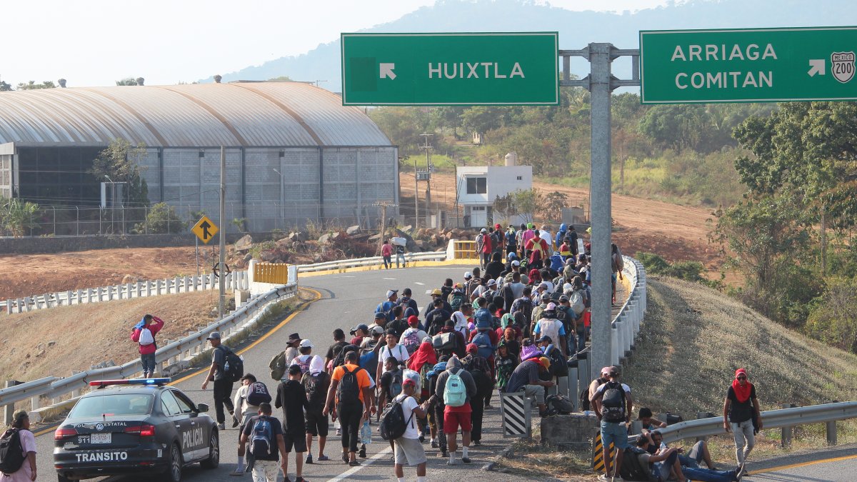 Migrantes caminan en caravana en una carretera de México.