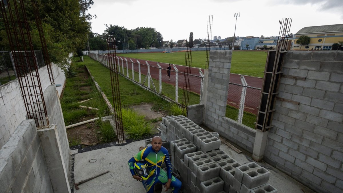 El piloto de la selección brasileña Edson Luques Bindilatti, con cinco participaciones en los Juegos Olímpicos de Invierno, posa en medio de las obras paralizadas por falta de financiación de su proyecto