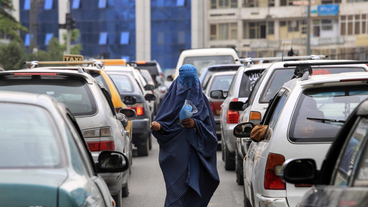 Una mujer afgana pide limosna en una calle de Kabul el 11 de abril de 2022.