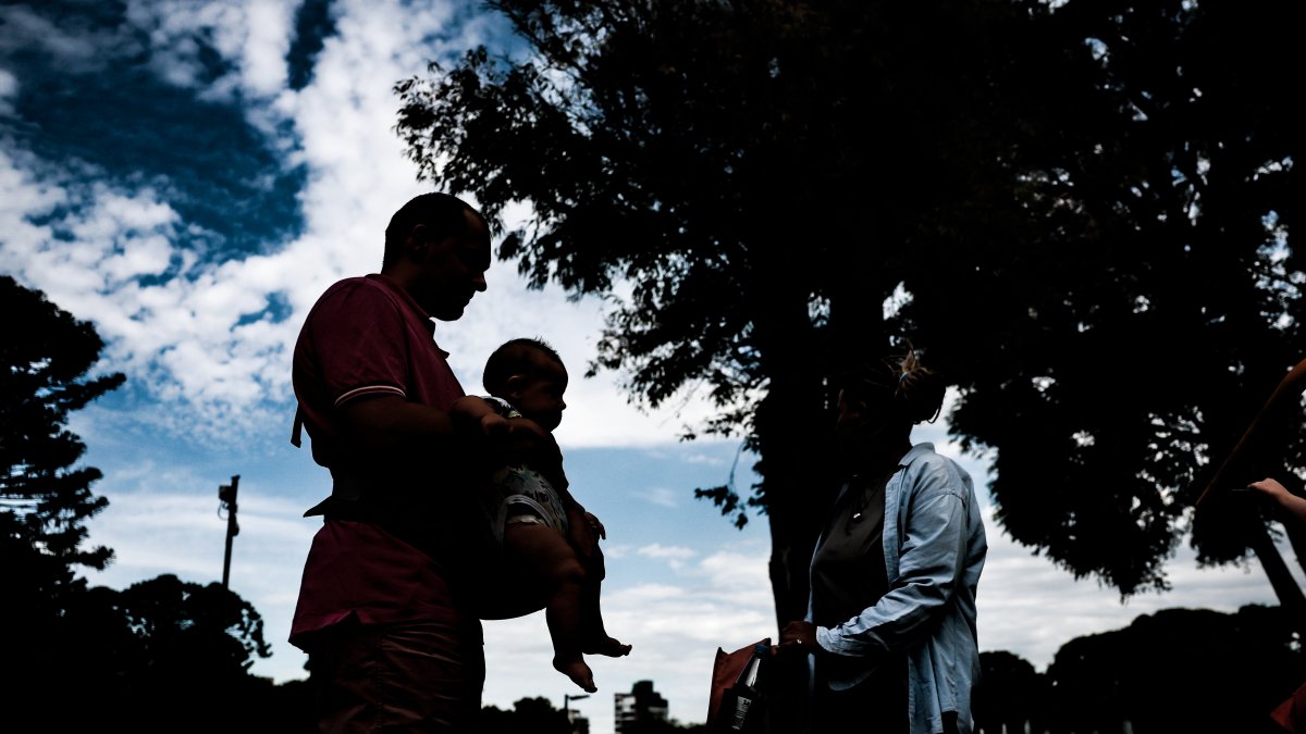 Instancia. Los inmigrantes Georgy Eliseev y Marina Morunova cuidan a sus hijos en un parque de Buenos Aires.