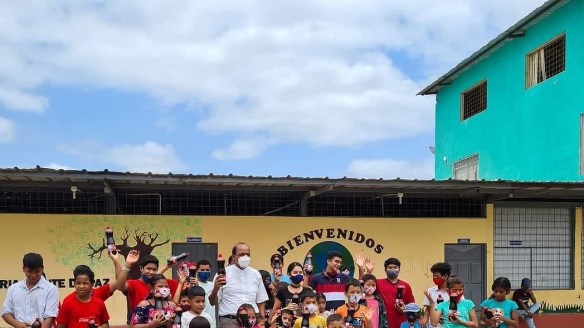 El padre Simón Mahish aparece en medio de un grupo de niños de la la unidad educativa El profeta Jeremías