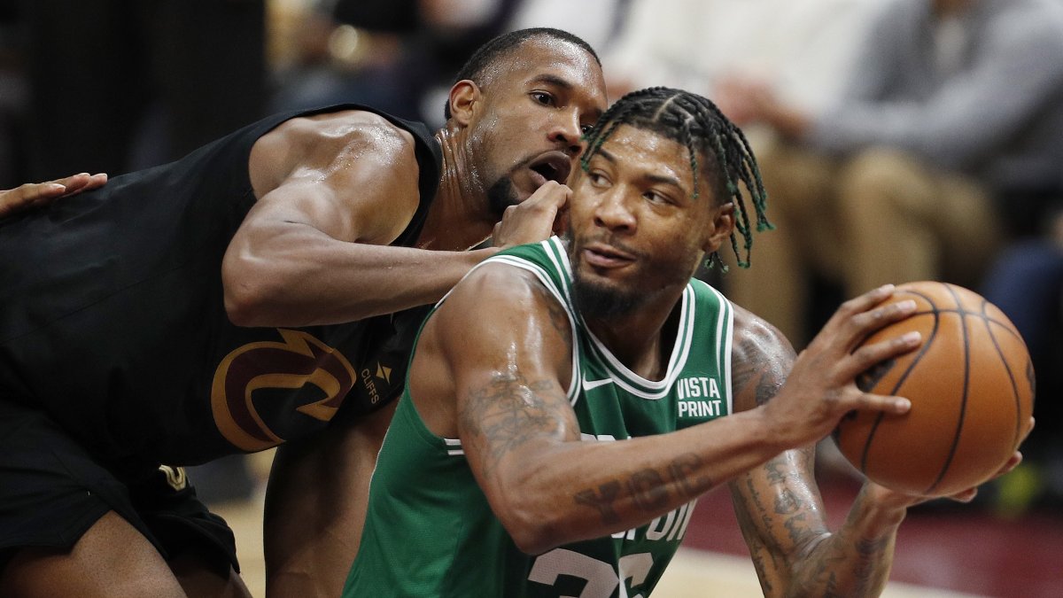 El alero de los Cleveland Cavaliers, Evan Mobley (i), defiende contra el escolta de los Boston Celtics, Marcus Smart (der.), durante el partido en el Rocket Mortgage Fieldhouse de Cleveland.