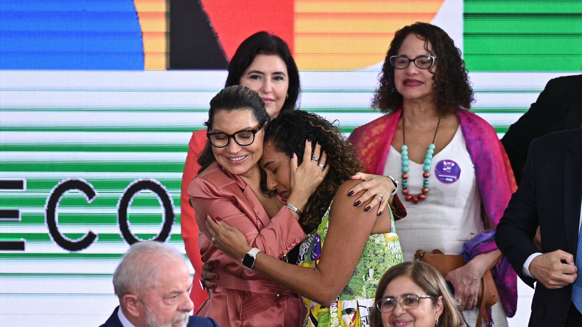 La primera dama Janja da Silva (c-i), abraza a la Ministra de Igualdad Racial, Anielle Franco (c-d), durante la ceremonia de celebración del Día Internacional de las Mujeres.