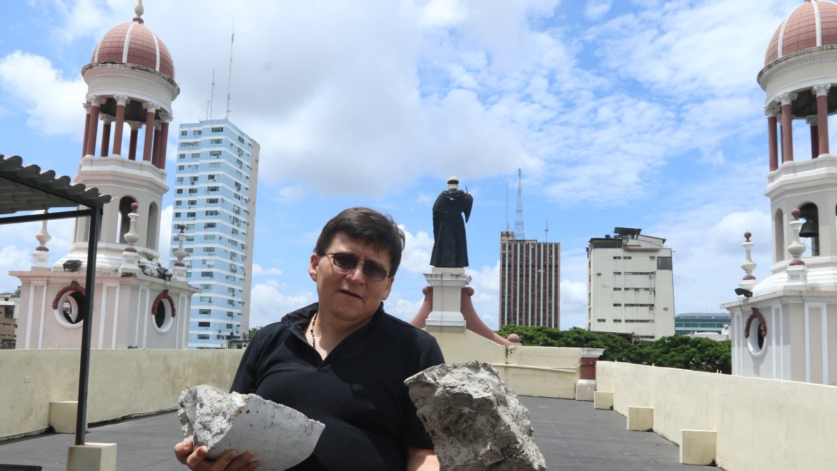 Daño. El padre Wilson Malavé sostiene los fragmentos de la cúpula de la iglesia San Agustín que se han caído.