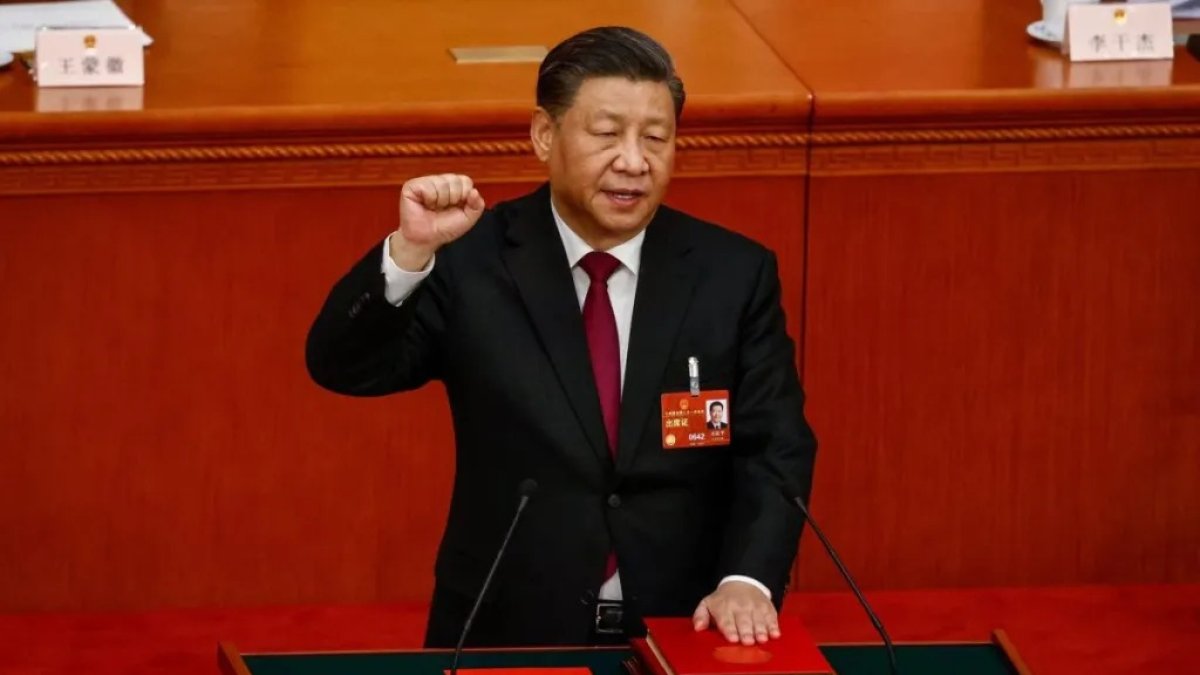 El presidente chino Xi Jinping saluda, puño en al término de la Asamblea Nacional Popular china que le ha designado para un tercer mandato.