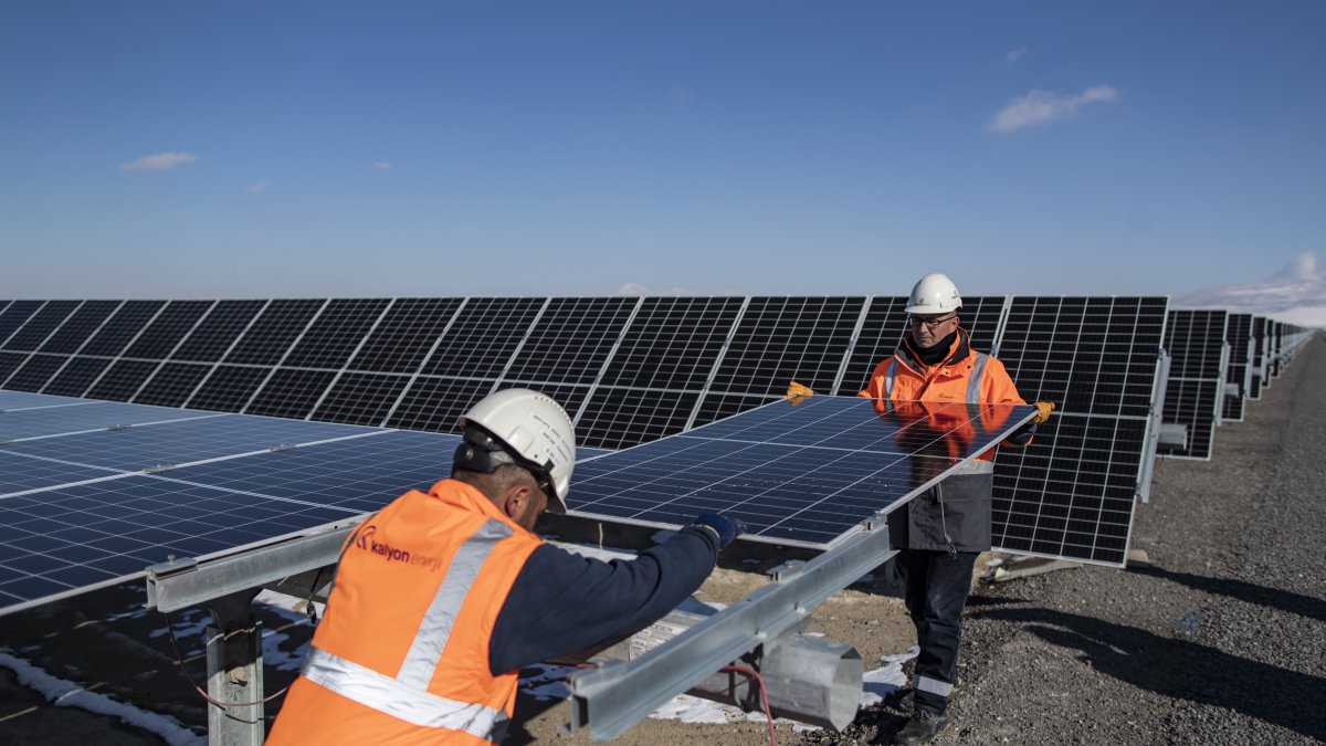 Dos técnicos reemplazan un panel fotovoltaico después de que fuera dañado por una piedra que rebotó en un automóvil que pasaba.