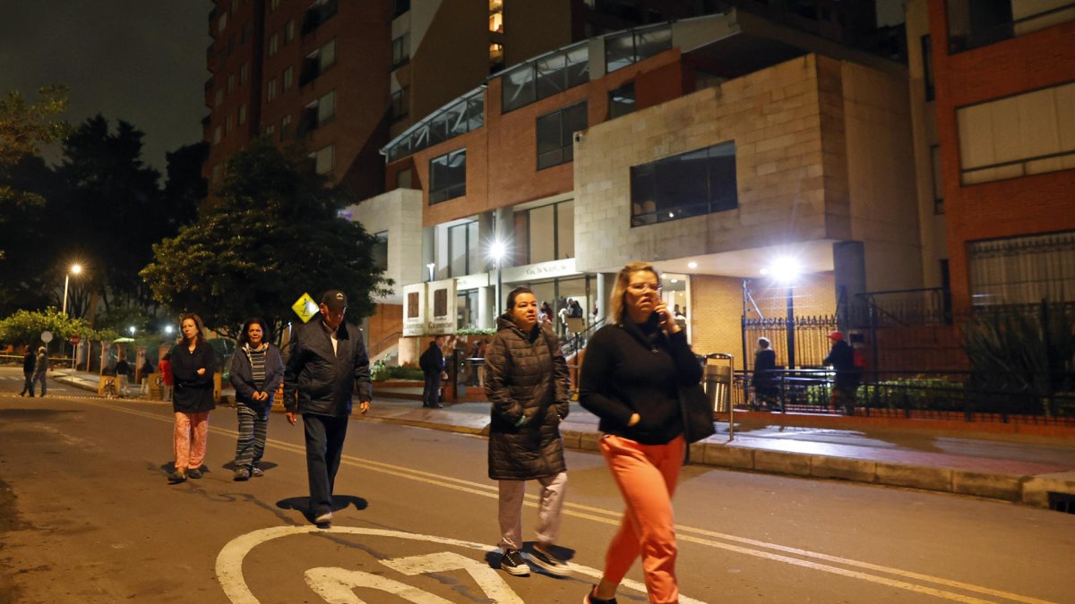 Residentes de un edificio salen de sus viviendas tras sentir el sismo en la madrugada del viernes, en Bogotá (Colombia).