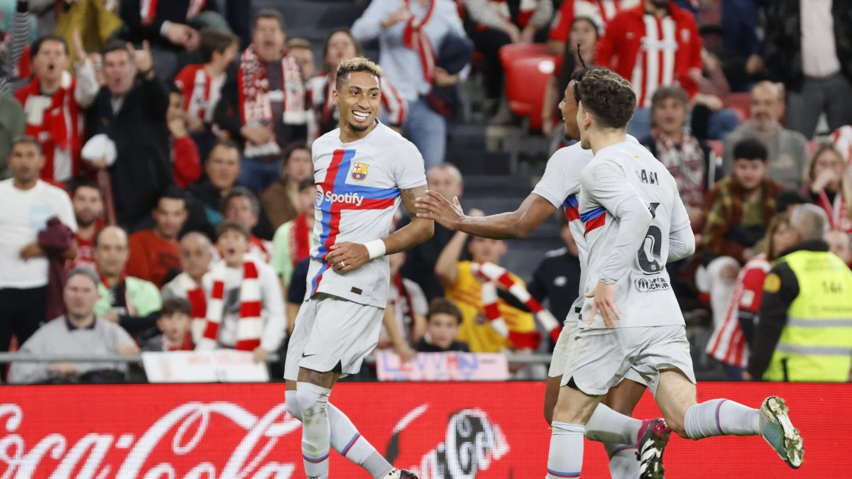 El delantero brasileño, Raphinha (i), del Barcelona, celebra con sus compañeros el primer y único gol frente al Athletic en el estadio de San Mamés, en Bilbao.