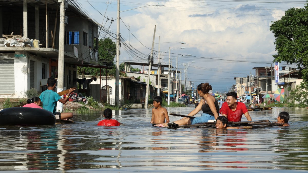 En flotadores o balsas, los habitantes de Milagro se movilizan por las lluvias.