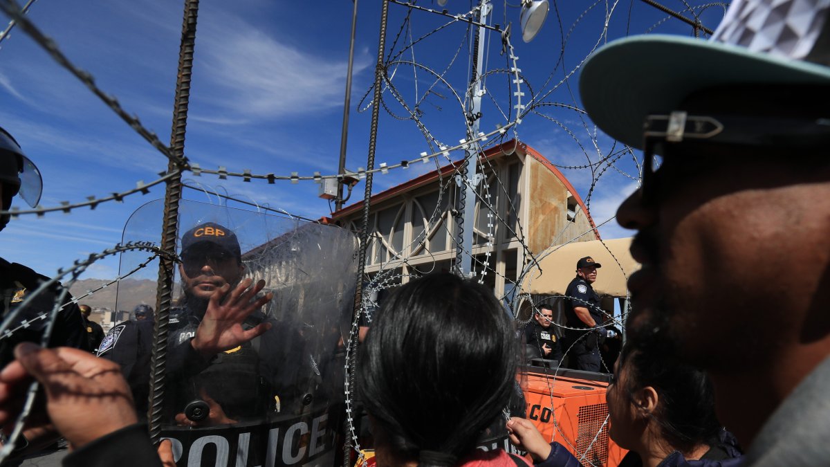 Policías estadounidenses acuden a controlar una protesta de cientos de migrantes.