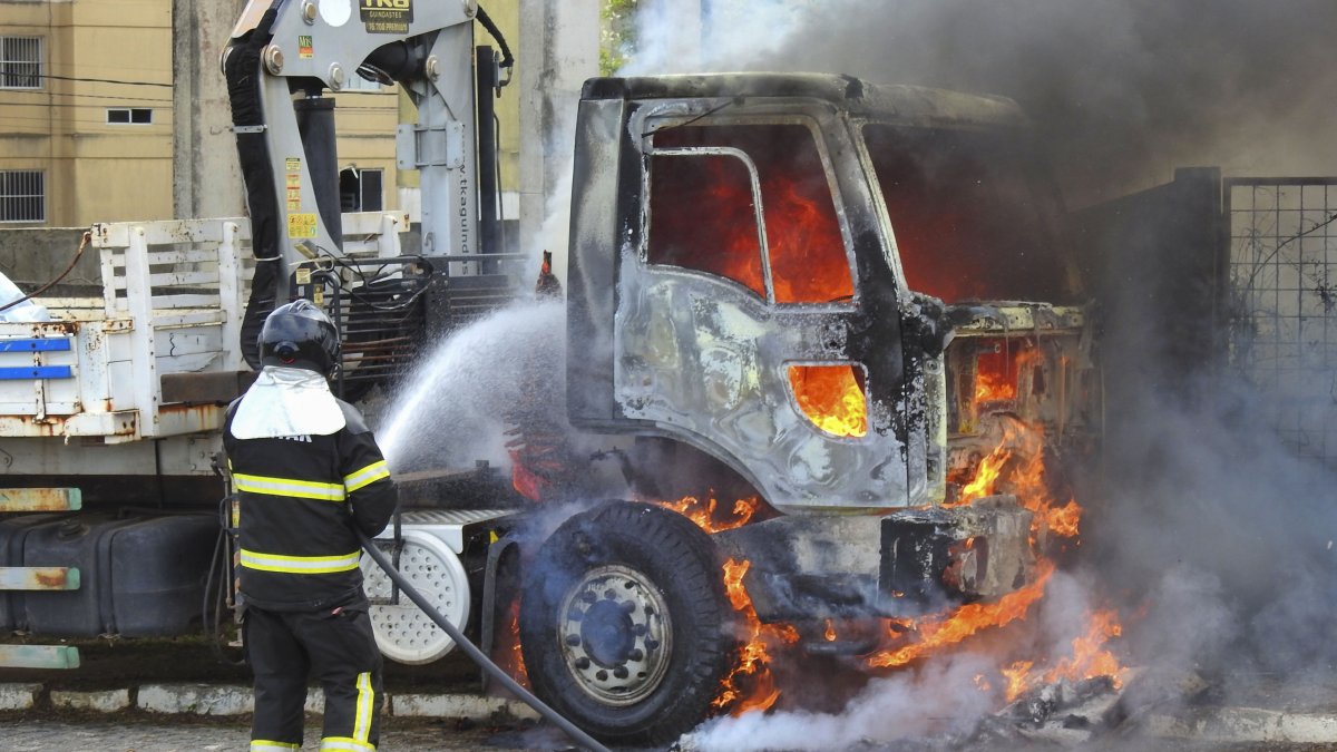 Un bombero intenta controlar el fuego de un camión en llamas, hoy, en Parnamirim, en el estado Río Grande del Norte (Brasil).