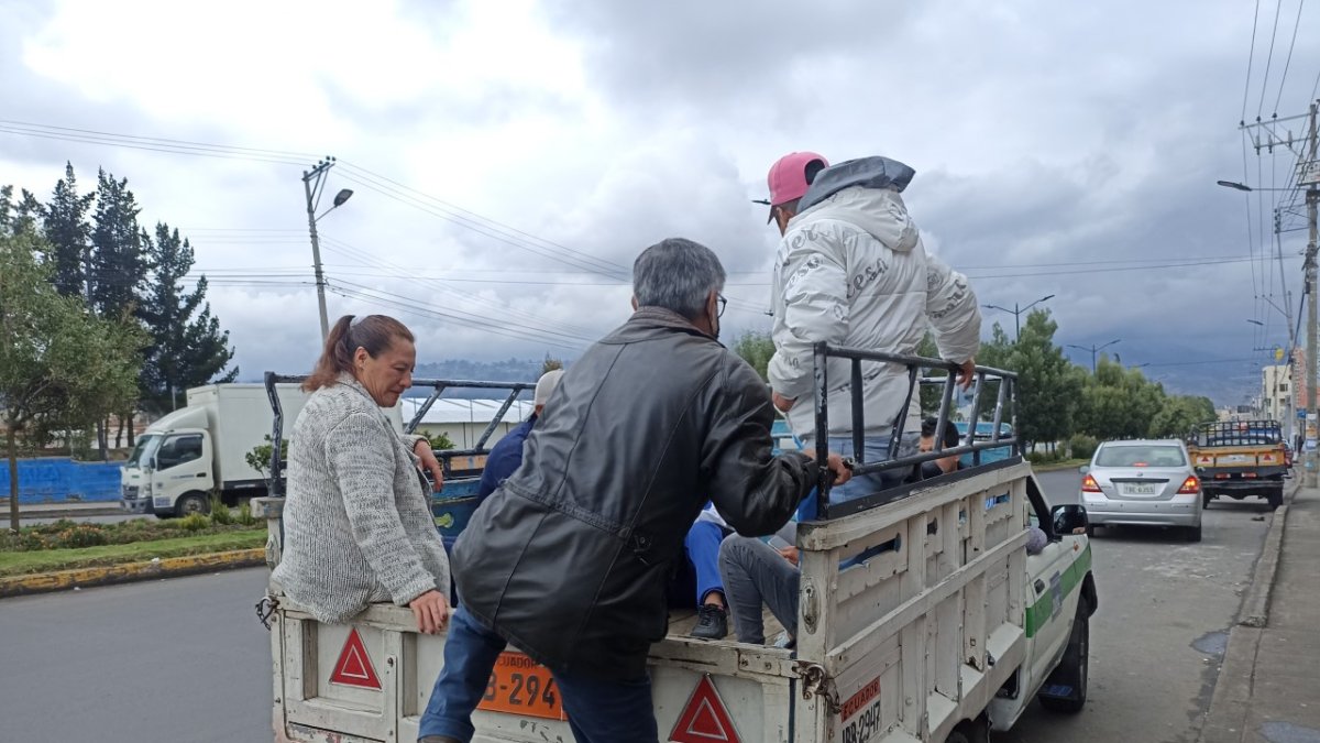 Camionetas cobran medio dólar para transportar a personas a ciudadanos en las veredas de la ciudad de Ambato.