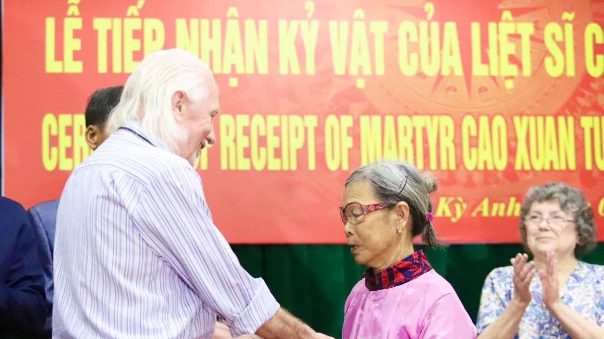 El veterano de guerra estadounidense Peter Mathews entrega el diario del fallecido soldado vietnamita Cao Van Tuat a su hermana.