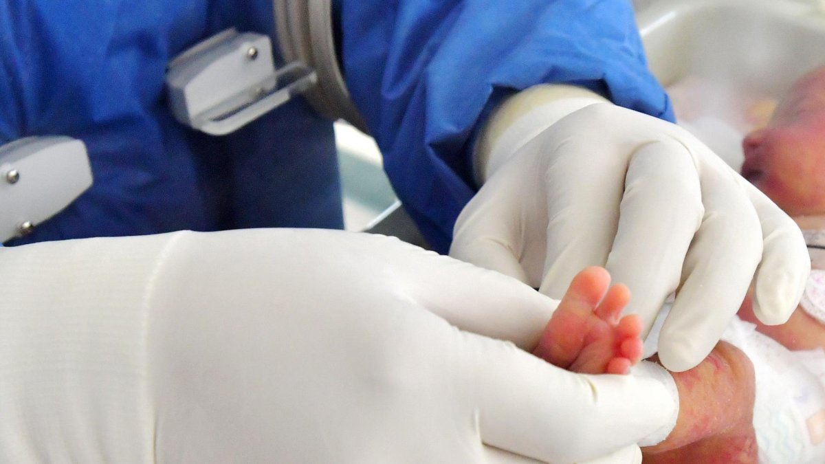 Fotografía de archivo de un sanitario atendiendo a un recién nacido.