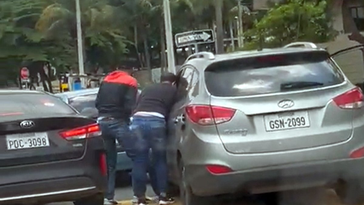 Instante en el que los delincuentes robaron a uno de los conductores que esperaba en la vía.