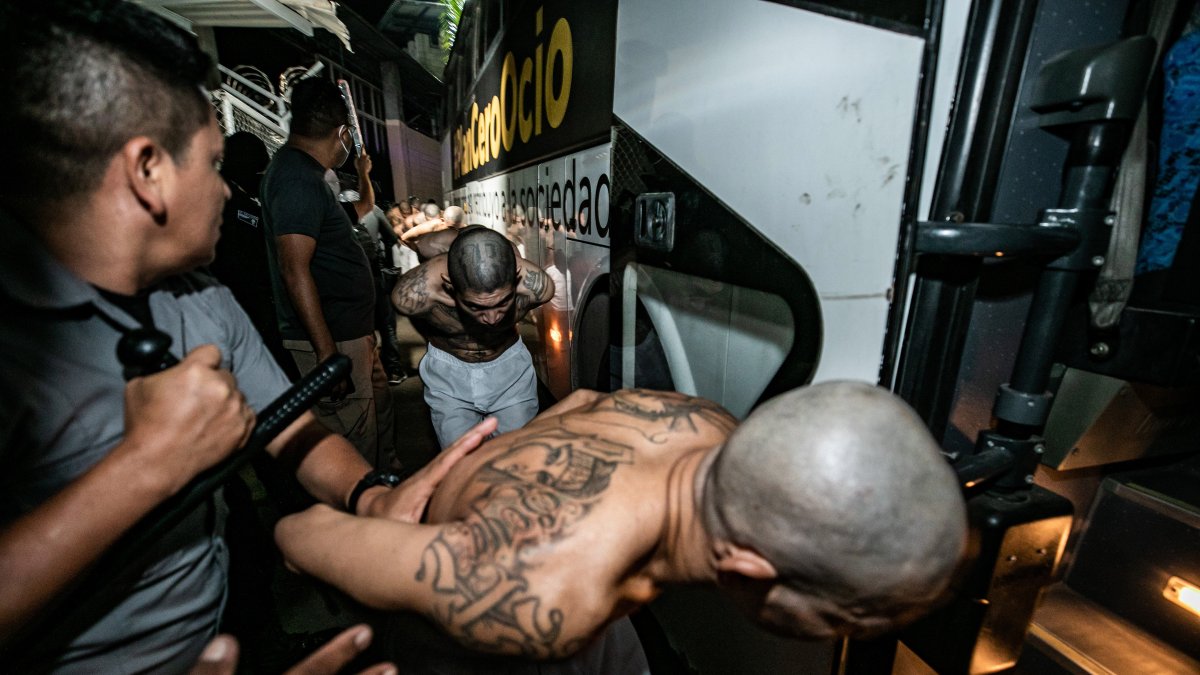 Fotografía cedida por la presidencia de El Salvador donde se observa el traslado de pandilleros a la cárcel denominada Centro de Confinamiento del Terrorismo, la madrugada del 15 de marzo.  