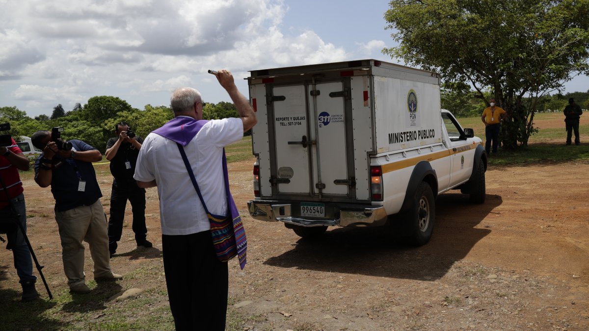 El monseñor José Luis Lacunza bendice los vehículos donde se encuentran los cuerpos de migrantes fallecidos durante un accidente en autobús el pasado mes de febrero, hoy en David (Panamá).