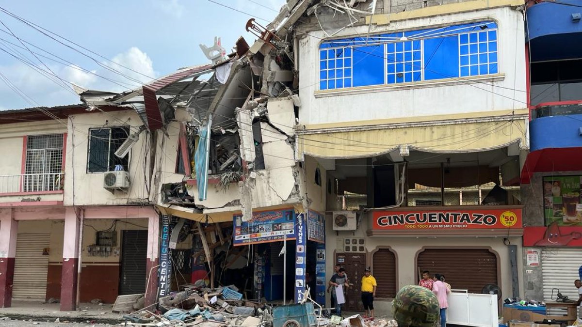 Los escombros de las casas derrumbadas son removidos por maquinaría de la prefectura
