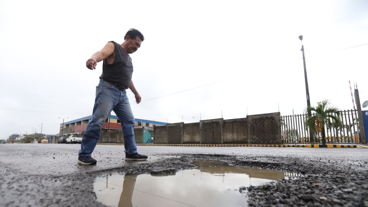 Reclamos. Un ciudadano se queja por los enormes baches que se observan en Mucho Lote 2, en Guayaquil. Los peatones también quieren demandar por los perjuicios provocados.
