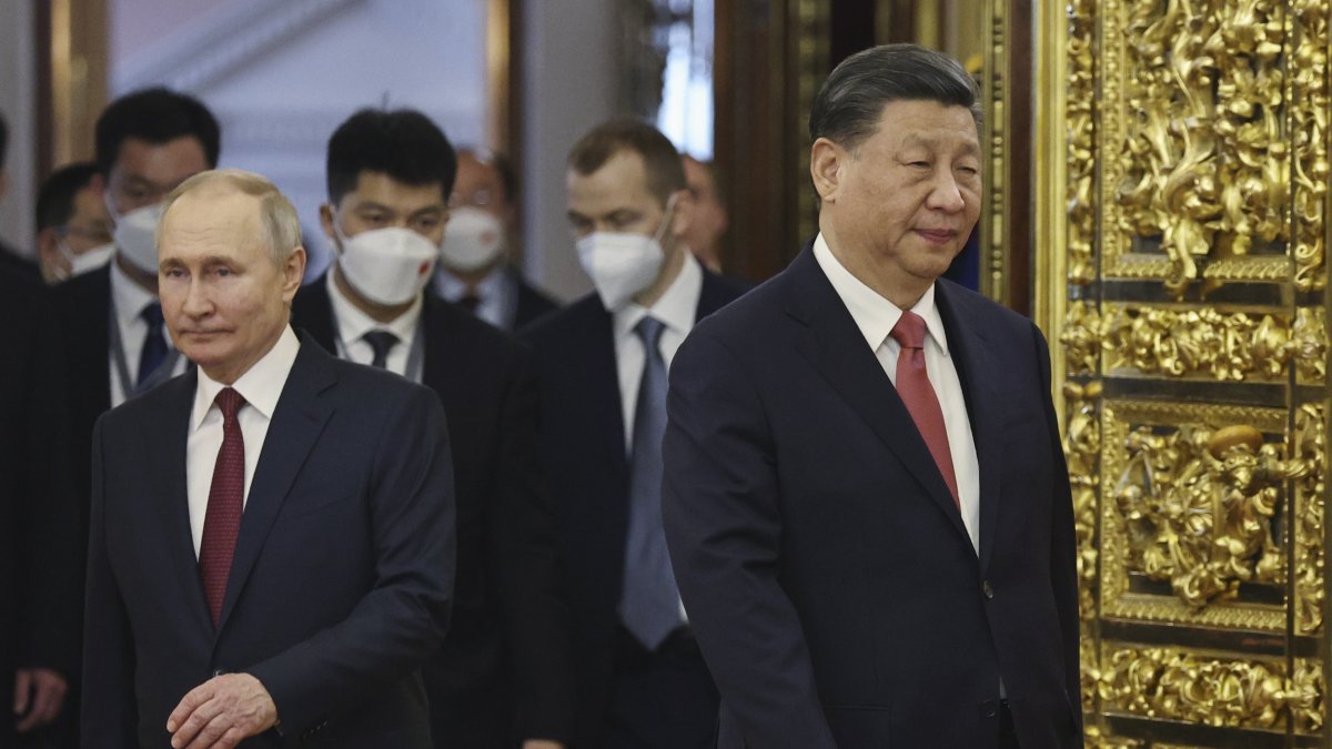 El presidente chino, Xi Jinping (D), y el presidente ruso, Vladimir Putin, ingresan a una sala para asistir a las conversaciones este 21 de marzo.