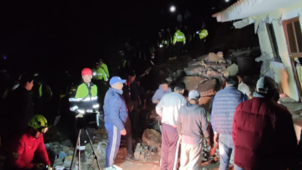 Bomberos de Alausí intentan rescatar a personas atrapadas bajo una de las casas.