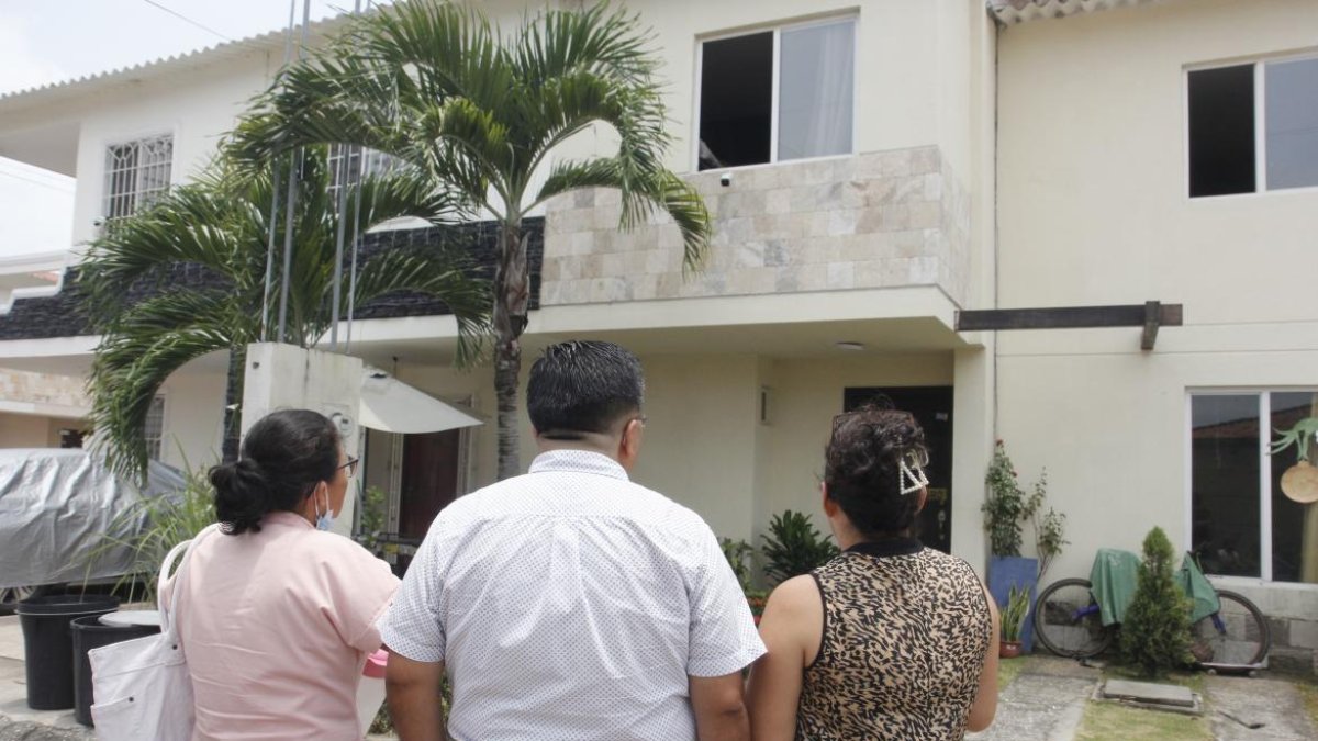 Vecinos observan, consternados, la casa donde el lunes 20 de marzo tres miembros de una familia murieron intoxicados.