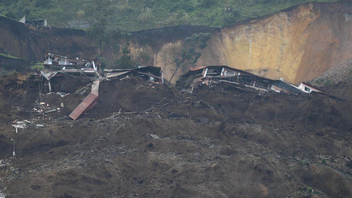 Familiares se lamentan hoy en la zona donde se presentó un deslizamiento de tierra, en Alausí (Ecuador).