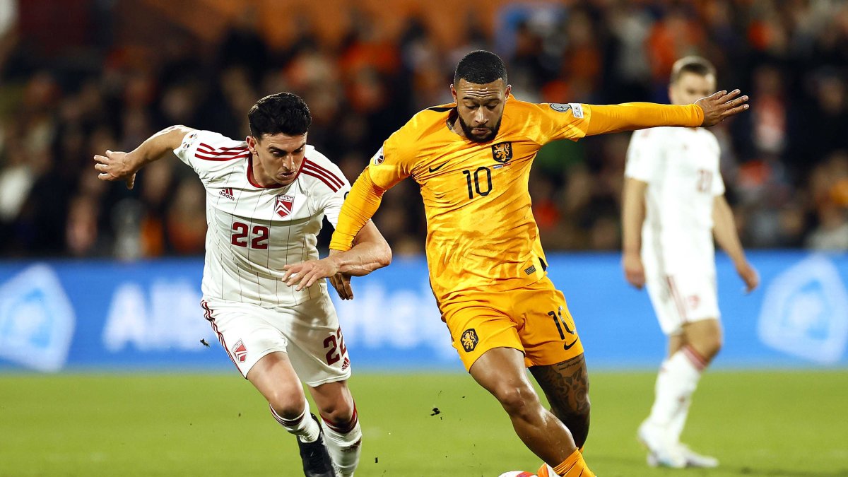 El delantero neerlandés Memphis Depay (d) en disputa del balón con el volante Graeme Torrilla (i) de Gibraltar.