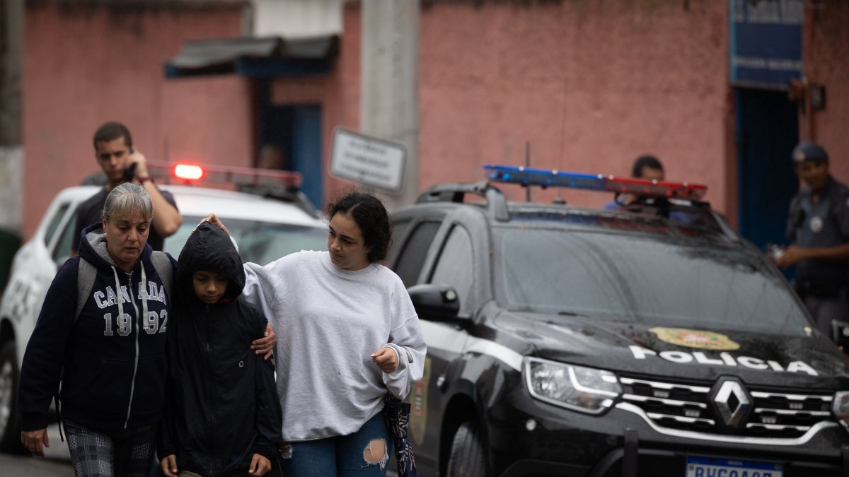 Familiares acompañan la salida de un estudiante del colegio público donde se ha presentado un ataque con arma punzante en São Paulo (Brasil).
