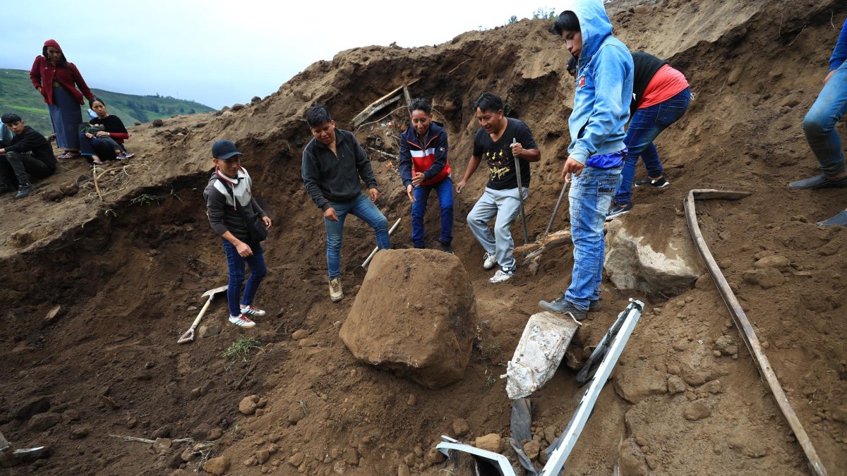Pobladores y rescatistas buscan a víctimas de un alud hoy, en Alausí (Ecuador).