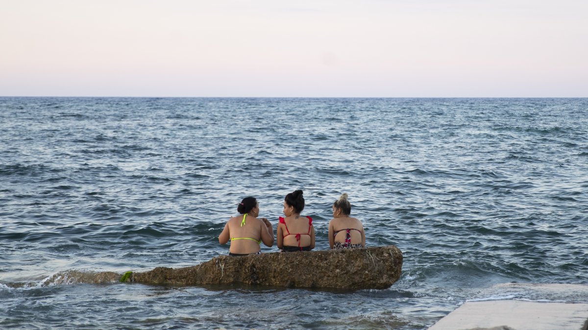 Tres mujeres disfrutan en una playa de La Habana.