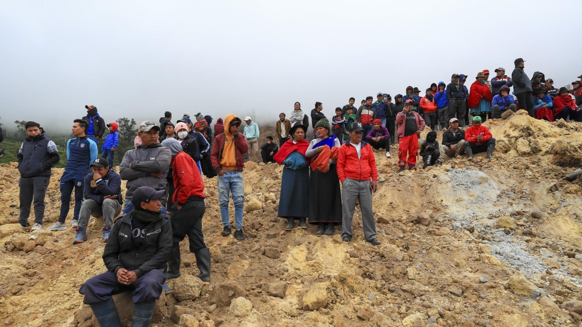 Familiares de desaparecidos observan como rescatistas buscan a victimas tras un alud, hoy en Alausí (Ecuador).