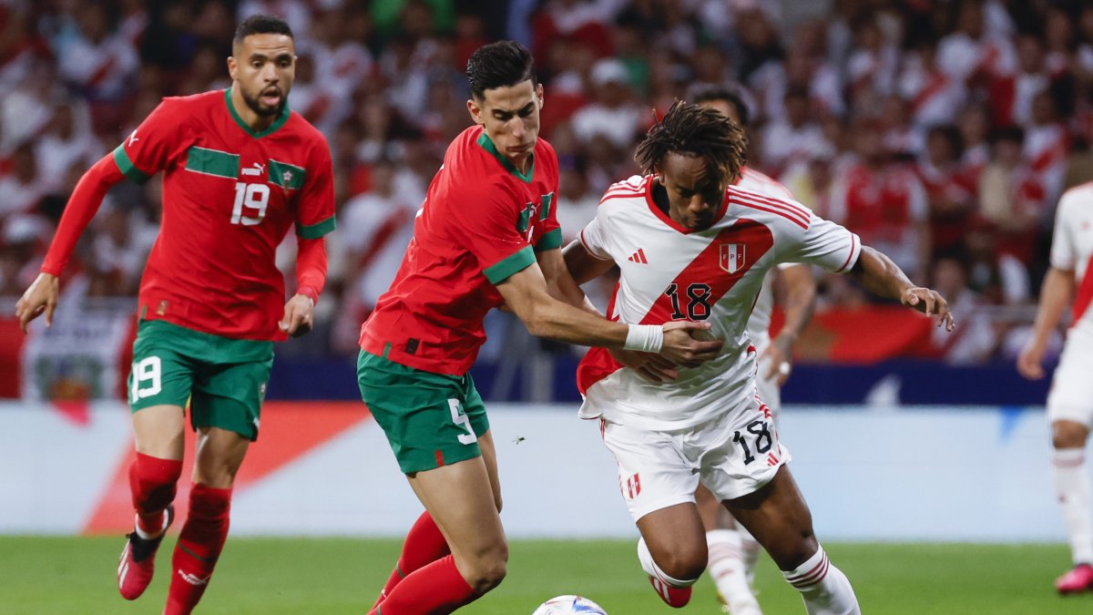 El lateral peruano André Carrillo (d) elude marca del central marroquí Nayef Aguerd (c).