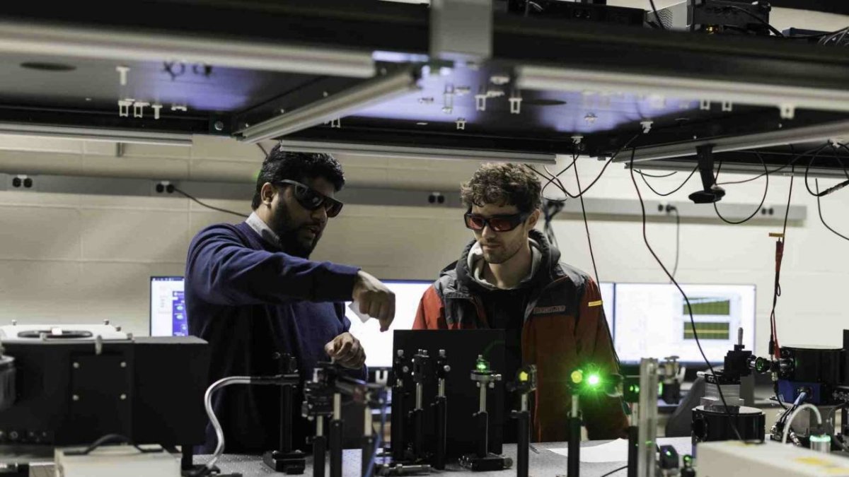 Los investigadores Ranga Dias (izquierda) y Nugzari Khalvashi-Sutter ajustan una matriz láser en su laboratorio de espectroscopia avanzada.