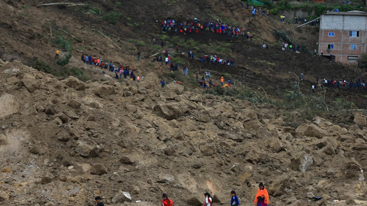Rescatistas y pobladores buscan a las víctimas del alud, en Alausí (Ecuador).