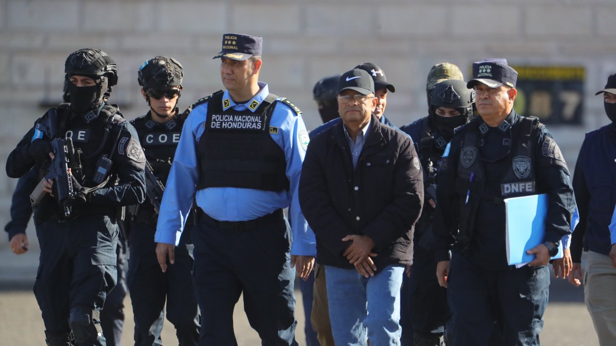 Policías trasladan hoy al exdiputado Midence Oquelí Martínez Turcios (c-d) rumbo a un avión para su extradición a Estados Unidos, en la Base Aérea Hernán Acosta Mejía en Tegucigalpa (Honduras).