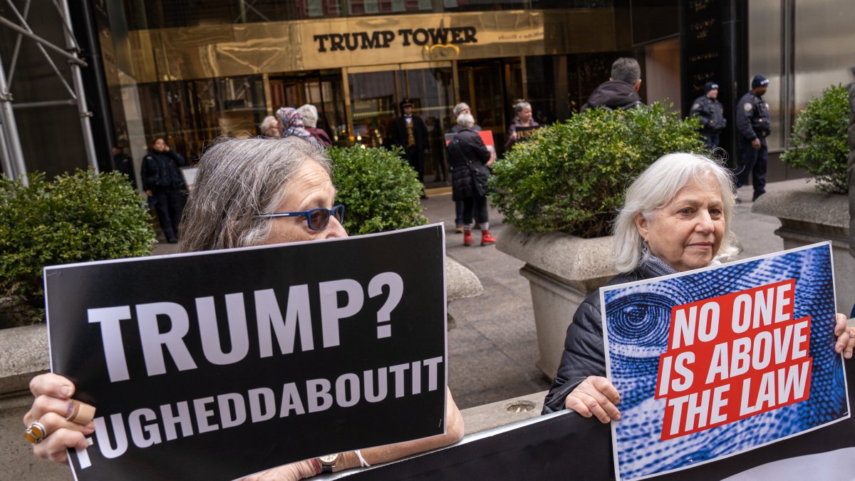 Unas personas sostienen pancartas en contra del expresidente Donald Trump durante una manifestación frente a la Torre Trump, ubicada en la Quinta Avenida, en Nueva York (Estados Unidos).