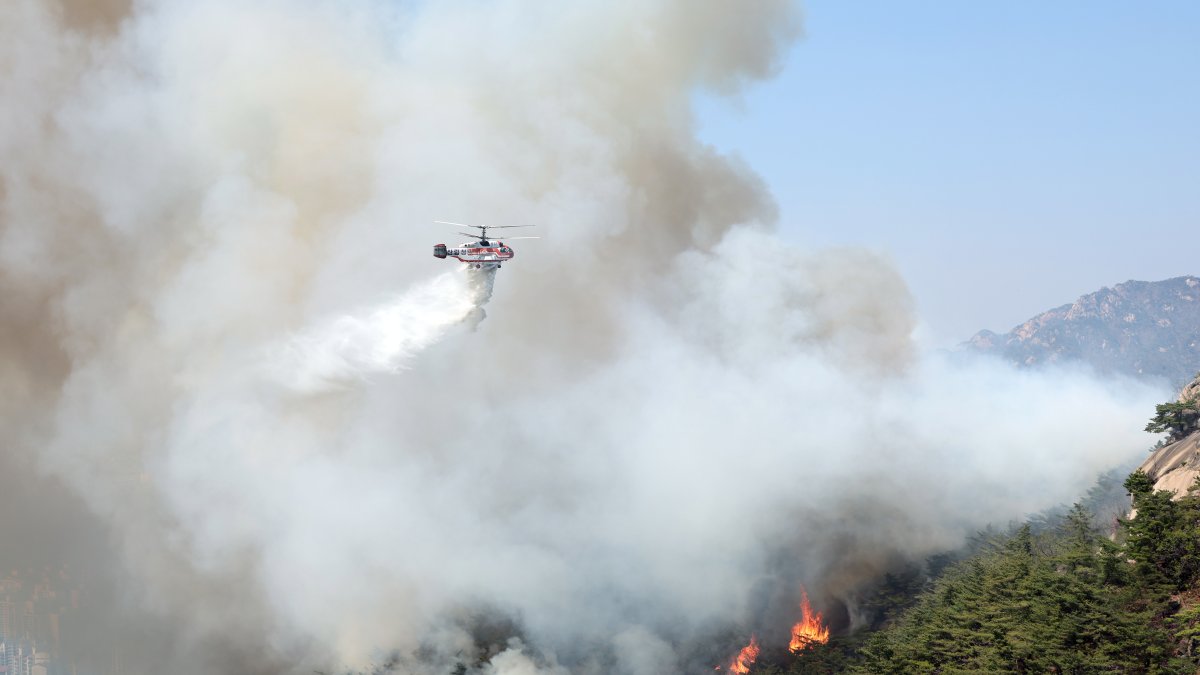 Equipos aéreos tratando de apagar el incendio declarado en un monte en el centro de Seul.