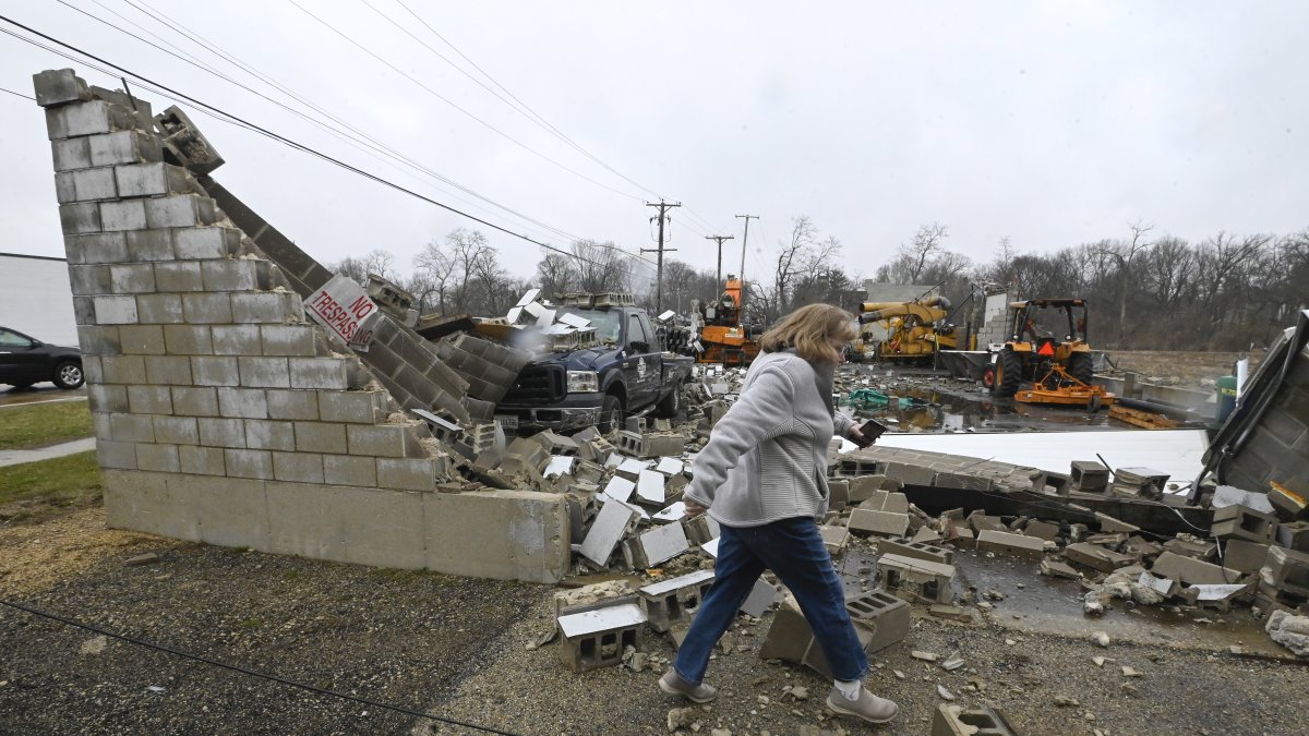 Una mujer pasa frente a un negocio destruido tras un tornado en Belvidere, Illinois, EE.UU.